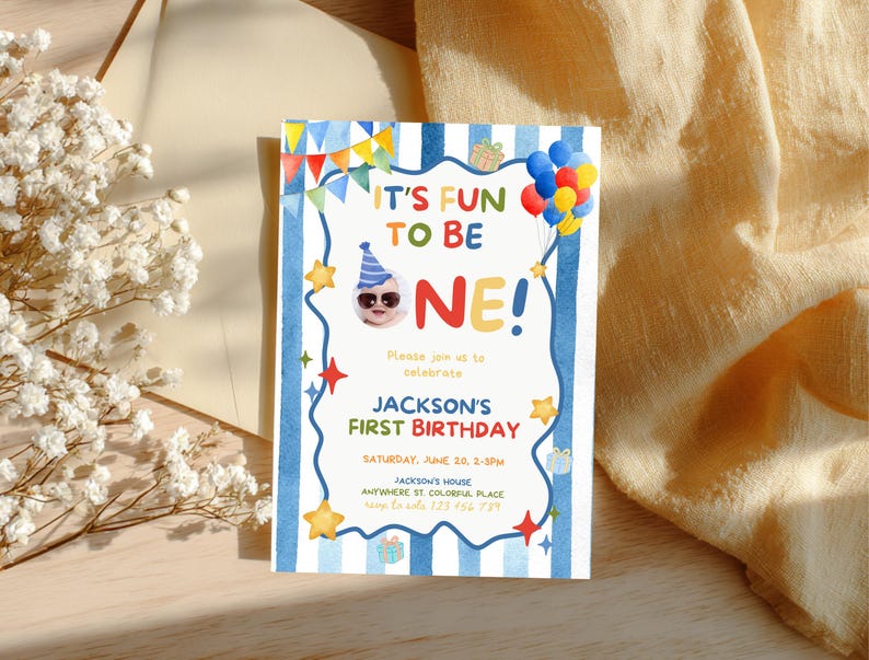 May include: A colorful first birthday invitation with the text "IT'S FUN TO BE ONE!" in a playful font. The invitation features a baby wearing sunglasses and a party hat, along with balloons, stars, and gift illustrations. The invitation is for Jackson's first birthday.