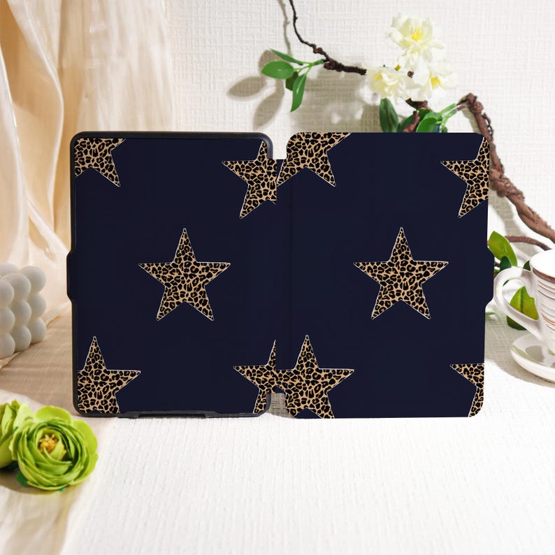 May include: A navy blue tablet case featuring a repeating pattern of leopard print stars. The case is open, revealing the interior. The stars are a tan color with dark brown spots.