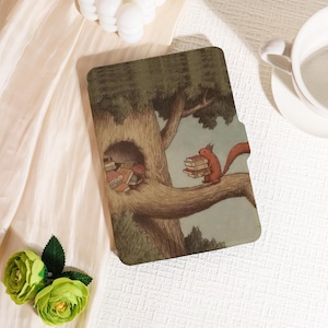 May include: A tablet case featuring a whimsical illustration of a squirrel carrying books on a tree branch. The artwork depicts a tree with a hollow filled with books, all set against a soft, muted background. The case is designed to protect a tablet.