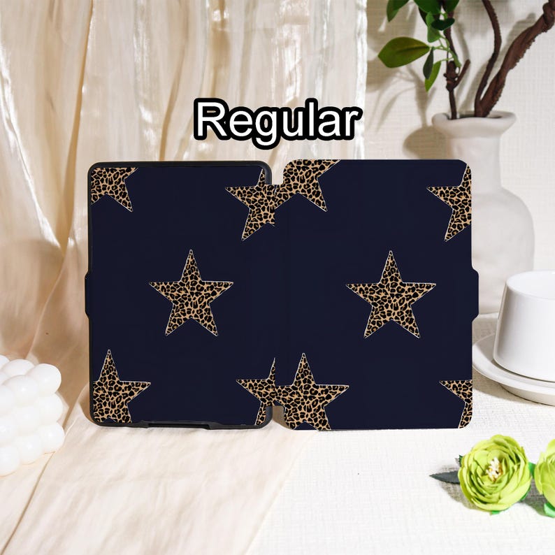 May include: A navy blue tablet case featuring a pattern of leopard print stars. The word "Regular" is printed in white at the top. The case is open, revealing the interior.