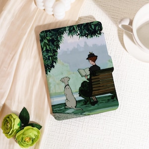 Peut inclure: Une coque de tablette représentant une scène de parc avec une femme lisant sur un banc, un chien dalmatien et de la verdure. La coque est posée sur un fond clair, avec un arrangement floral.