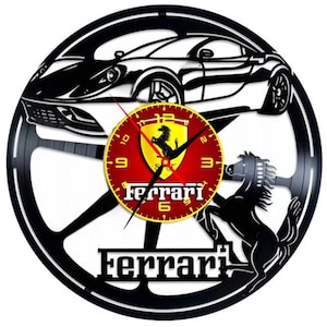 May include: Black vinyl record clock featuring a silhouette of a Ferrari car, the Ferrari logo, and the word "Ferrari" in white lettering.