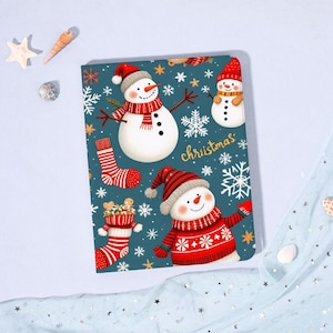 May include: A teal notebook with a festive Christmas design. The cover features snowmen, snowflakes, and the word "Christmas" in gold script. Red and white striped socks and a stocking are also included in the design.