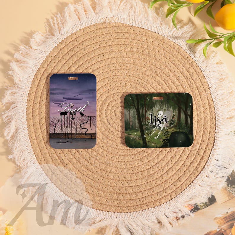 May include: Two rectangular luggage tags. One features a purple and gray night scene with the name "Smith" and a crow. The other tag displays a forest scene with the name "Lisa" and a skeleton. Both tags have a hole for attachment.