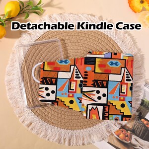 May include: A detachable Kindle case with a colorful geometric pattern in orange, blue, yellow, and black. The case is open, revealing a clear plastic frame. The text "Detachable Kindle Case" is displayed at the top.
