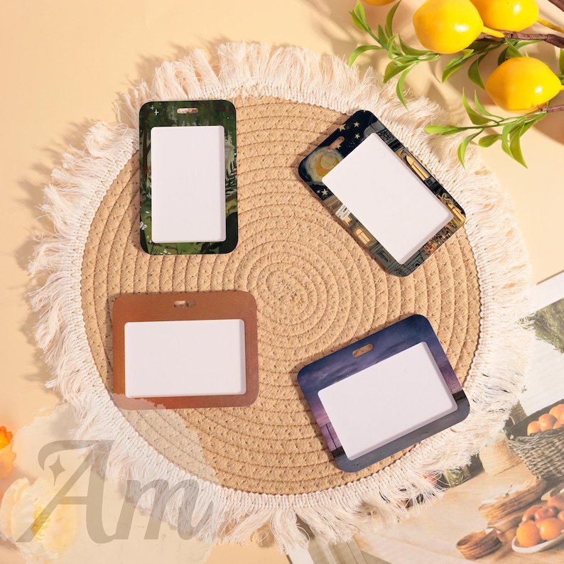 May include: Four rectangular ID badge holders with different designs. One has a green and black camouflage pattern, another features a night sky with a moon and stars, a third is brown, and the last has a purple and blue sunset scene.