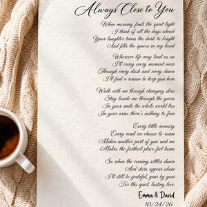 May include: A rectangular off-white paper print featuring the black printed title Always Close to You, followed by a poem, the names Emma & David, and the date 10/24/26. The text is written in a black cursive and serif font on textured paper.