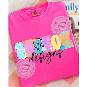 Pu&ograve; includere: Una maglietta rosa acceso con la parola "CUSTOM" in lettere colorate e giocose. La parola "designs" &egrave; scritta in corsivo nero sotto. La maglietta presenta un design retr&ograve; con fiori, una faccina sorridente e un motivo a scacchi.