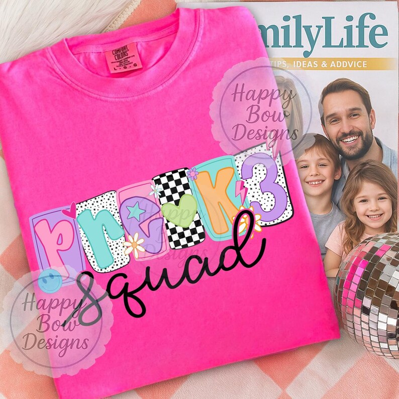 Pu&ograve; includere: Una maglietta rosa acceso con la scritta "Pre-K 3 Squad" in un design colorato e giocoso. Il testo presenta un mix di motivi, tra cui scacchiere, stelle e cuori. La maglietta &egrave; piegata e presentata su una superficie a fantasia.