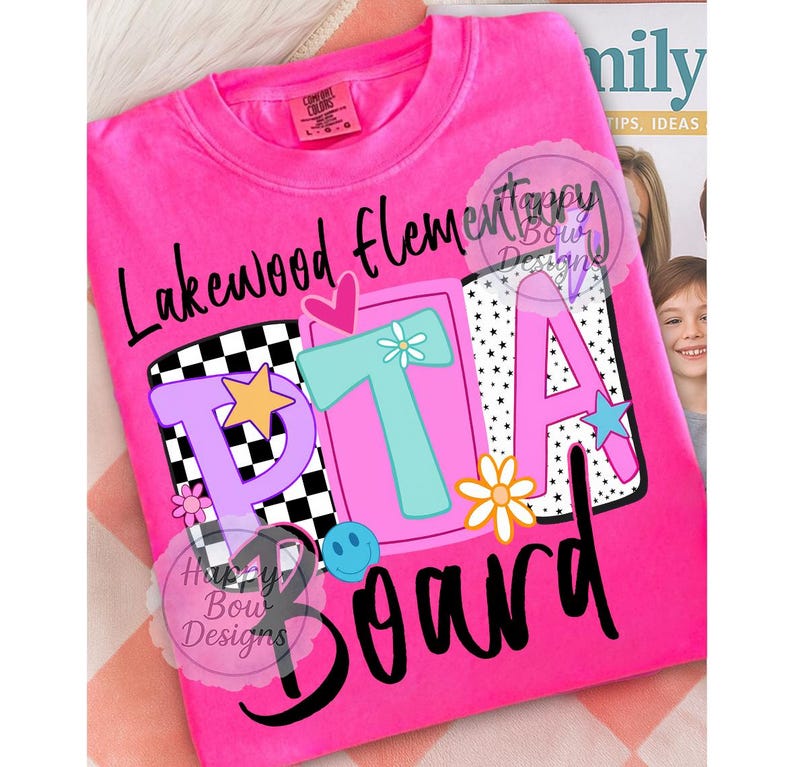 Pu&ograve; includere: T-shirt rosa acceso con la scritta "Lakewood Elementary PTA Board" in corsivo nero. Le lettere "PTA" sono in un design colorato con stelle, fiori e una faccina sorridente. La maglietta ha un'etichetta Comfort Colors.
