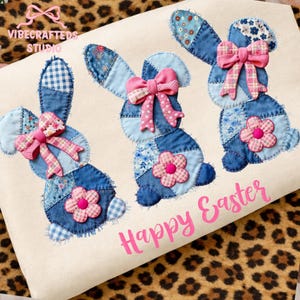 May include: A cream-colored fabric featuring three denim patchwork bunny figures with pink bows and flower accents. The words "Happy Easter" are printed in pink below the bunnies. The top left corner has the text "VIBECRAFTED STUDIO".