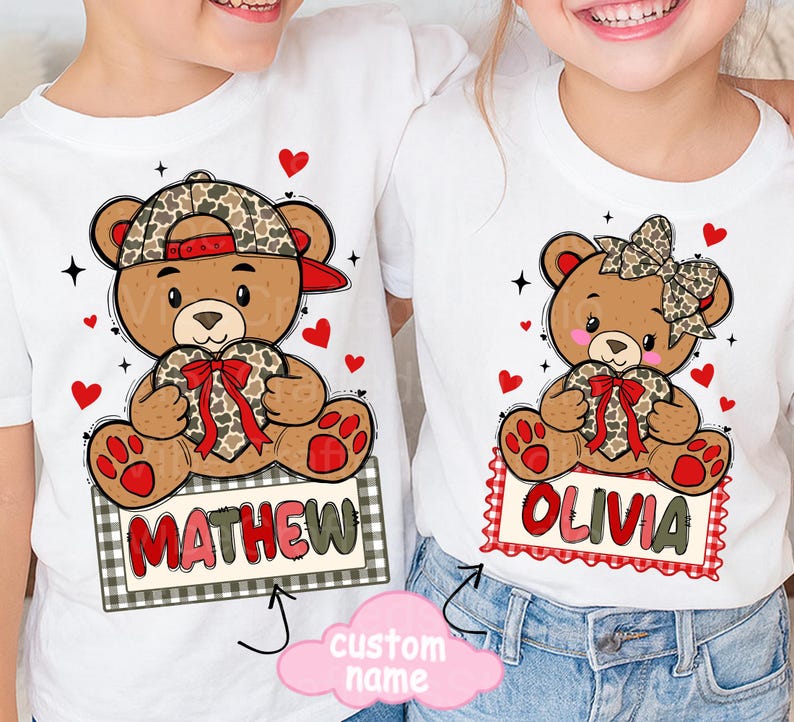 May include: White t-shirts featuring cartoon teddy bears holding heart-shaped gifts. One bear wears a camo hat and the name "MATHEW" on a sign. The other bear has a bow and the name "OLIVIA". Red hearts and stars decorate the shirts.