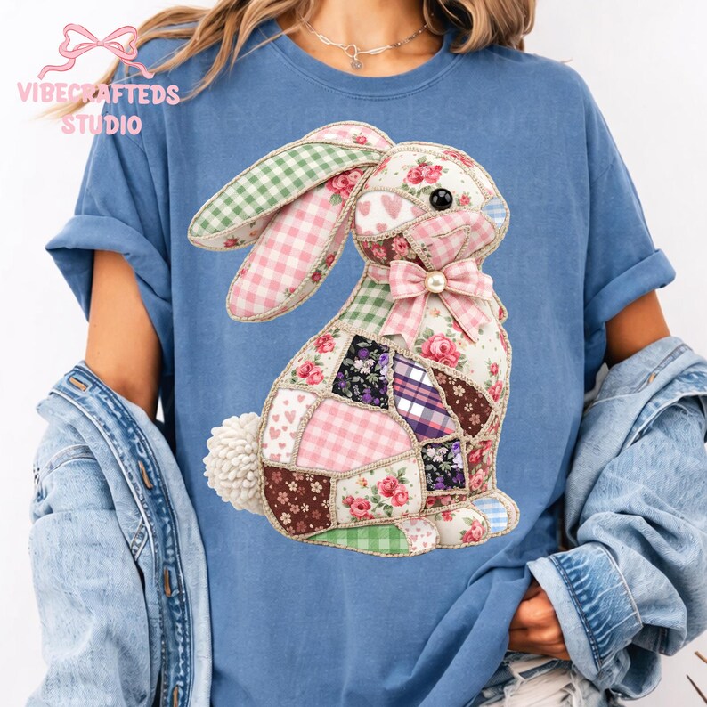 May include: A blue t-shirt featuring a patchwork bunny design. The bunny is made of various fabric patterns, including gingham, floral, and heart prints. A pink bow adorns the bunny's neck, and the shirt has the text "VIBECRAFTEDS STUDIO" at the top.