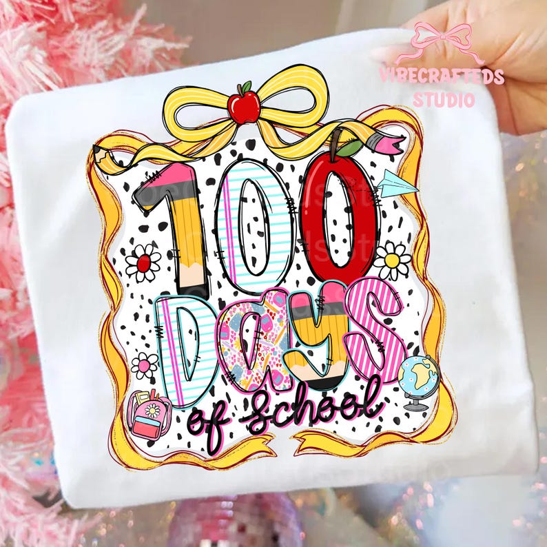Puede incluir: Camiseta blanca con un gr&aacute;fico colorido que celebra los 100 d&iacute;as de escuela. El dise&ntilde;o incluye un gran "100" con un l&aacute;piz y una manzana, adem&aacute;s de las palabras "Days of School". Una cinta amarilla y detalles florales enmarcan el dise&ntilde;o.