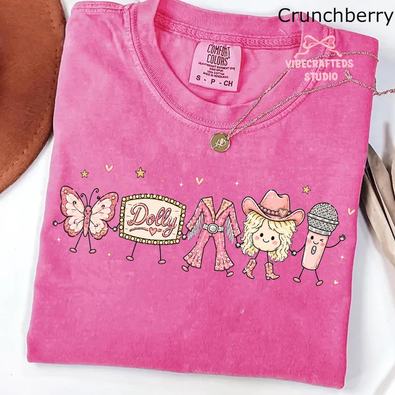 May include: A pink short-sleeve t-shirt featuring a graphic print of a butterfly, a marquee sign with the text Dolly, a fringed outfit, a blonde character wearing a cowboy hat and boots, and a microphone, all connected by thin black lines.