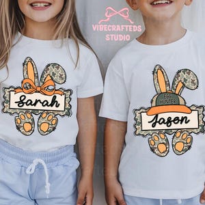 May include: White t-shirts with Easter-themed graphics. One shirt features a bunny with a bow and the name "Sarah". The other shirt has a bunny with a hat and the name "Jason". Both shirts have paw prints.