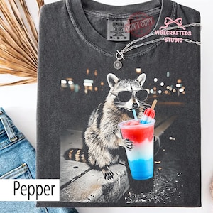 4 juli tvättbjörn dricker patriotisk slush komfortfärger skjorta, rolig amerikansk meme-tröja, röd vit blå glassdryckskjorta