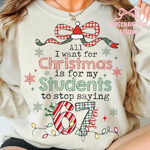 Könnte beinhalten: Cremefarbenes Sweatshirt mit einem Weihnachtsmotiv. Das Design umfasst eine rot-grüne Schleife, Schneeflocken und den Text "All I want for Christmas is for my Students to stop saying 67 Seven."