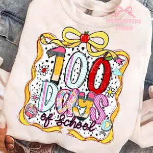 Puede incluir: Sudadera blanca con un gr&aacute;fico colorido que celebra los 100 d&iacute;as de escuela. El dise&ntilde;o incluye el texto "100 Days of School" con l&aacute;pices, una manzana, flores y un globo terr&aacute;queo. Una cinta y un lazo amarillos enmarcan el dise&ntilde;o.