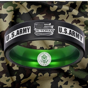 May include: Black ring with the text "U.S. ARMY" on the top and a green interior. The ring has the words "VETERAN" and a US flag design. The inside of the ring has the US Army seal.