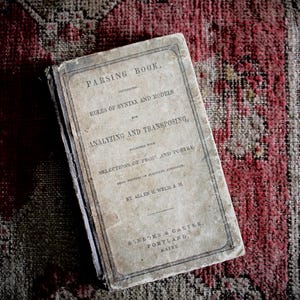 May include: An antique book titled Parsing Book, Containing Rules of Syntax and Models for Analyzing and Transposing, Together with Selections of Prose and Poetry, from Writers of Standard Authority, by Allen H. Weld, A.M., Sanborn & Carter, Portland, Maine.