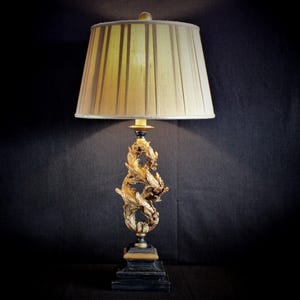 Lampada Bradburn: base a foglia d'acanto dorata, paralume in seta plissettata.