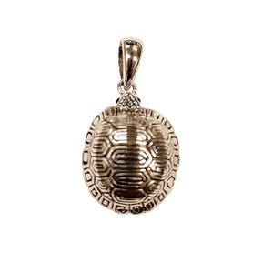 May include: Silver turtle pendant with a detailed shell design. The pendant has a loop at the top for attaching to a chain.
