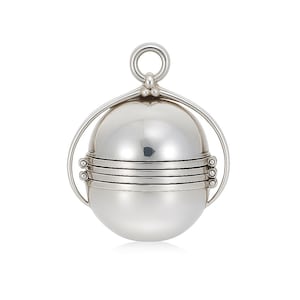 May include: A silver spherical pendant with a hinged design. It has a ring at the top for hanging and horizontal bands around the middle. The design is smooth and reflective, with a polished finish. The pendant is likely made of metal.