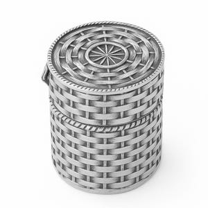 Puede incluir: Una caja redonda plateada con un diseño de cesta tejida. La tapa presenta un patrón circular con un centro en forma de estrella. La caja es cilíndrica con una tapa con bisagras y un patrón de tejido de cesta texturizado.