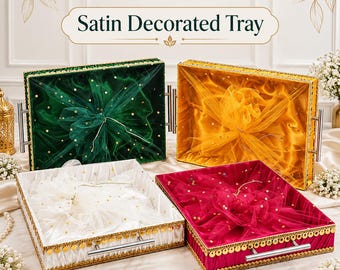 May include: Four rectangular trays with satin lining and metallic gold trim. Each tray features a sheer, polka-dot tulle overlay gathered in the center and two silver-toned metal handles. The trays are green, yellow, white, and magenta.