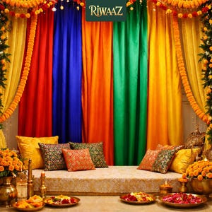 May include: A festive backdrop featuring vertical fabric panels in red, blue, orange, green, and yellow, adorned with marigold garlands. A seating area includes patterned throw pillows, brass vessels, and plates filled with flower petals.