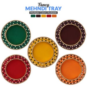 May include: Five round decorative trays with gold trim and a variety of colours, including green, brown, yellow, red, and orange. The trays are labelled "Fancy Mehndi Tray" and "Multiple Colours Available".
