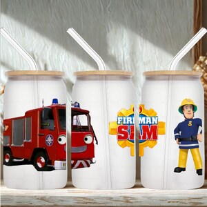 May include: Three white glass tumblers with bamboo lids and clear straws, each decorated with a Fireman Sam design. One features a red fire engine, another the show's logo, and the third, a cartoon fireman in uniform.