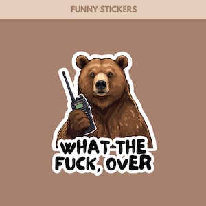Op de afbeelding: Illustratie van een bruine beer met een zwarte walkietalkie. De sticker heeft de tekst "WHAT THE FUCK, OVER" in het wit. De woorden "FUNNY STICKERS" staan bovenaan de afbeelding.