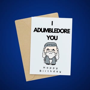 Op de afbeelding: Een witte kaart met een cartoonillustratie van Albus Perkamentus. De kaart zegt "I Adumbledore You" en "Happy Birthday".