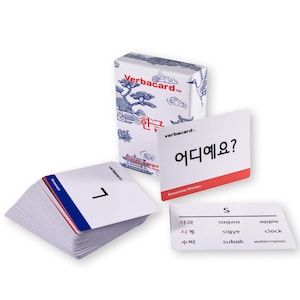 May include: A set of Verbacard Korean language learning flashcards. The box and cards feature blue and white designs with Korean text. One card displays the number 7, and another shows the phrase "Where is it?" in Korean.