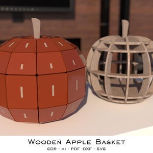 Könnte beinhalten: Zwei holzförmige Apfelkörbe. Einer ist rotbraun mit weißen rechteckigen Akzenten, der andere ein helles, offenes Design. Beide haben einen Stiel. Der Text "Wooden Apple Basket" steht unten.