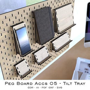 Pode incluir: Um painel perfurado de madeira com várias prateleiras e suportes. Um smartphone, um caderno cinza e várias bandejas de madeira são exibidos. O painel perfurado tem uma grade de furos para fixar acessórios. O texto "PEG BOARD ACCS 05 - TILT TRAY" é visível.