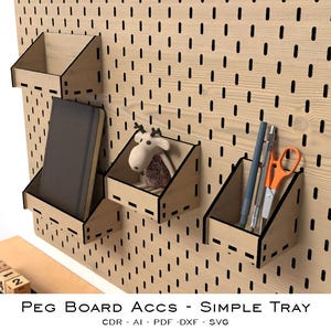 Puede incluir: Panel perforado de madera con varias bandejas pequeñas en ángulo que contienen un cuaderno, un peluche, bolígrafos y tijeras. El panel perforado está montado en una pared blanca. El texto "PEG BOARD ACCS - SIMPLE TRAY" es visible en la parte inferior.