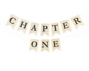 May include: A banner with the words "CHAPTER ONE" printed in black on individual flag-shaped pieces. The flags have a vintage look, with a background resembling aged book pages. The banner is strung on a thin white string against a white background.