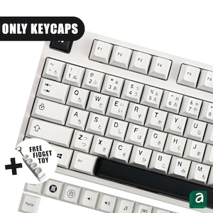 Pode incluir: Teclas de teclado mecânico brancas com caracteres japoneses e letras inglesas. A imagem inclui o texto "ONLY KEYCAPS" e um brinquedo fidget grátis. As teclas são brancas com letras pretas.