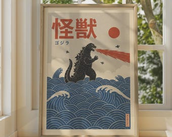 May include: A framed poster featuring a black Godzilla figure breathing red fire over stylized blue ocean waves. The text includes the Japanese characters for Kaiju and Godzilla, a red sun, and small black airplanes against a light background.