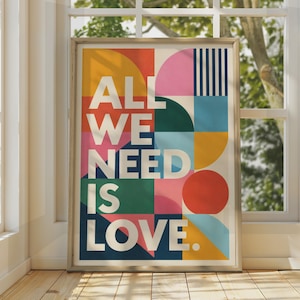 Può includere: Una stampa artistica da parete rettangolare con il testo bianco ALL WE NEED IS LOVE. Lo sfondo è composto da forme geometriche in colori vivaci tra cui giallo, rosa, blu scuro, verde e rosso, disposte in una griglia di quadrati e cerchi.