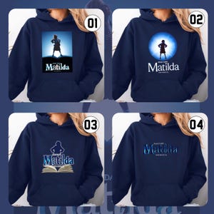 May include: Four navy blue hoodies, each with a different design related to the musical "Matilda". The designs include a silhouette of a girl, the musical's title, and an open book.