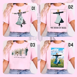 May include: Four pink t-shirts with different designs from the musical "The Sound of Music." Each shirt features a different graphic: a silhouette of a woman, the movie title, and a group of people. The shirts are displayed on a person.