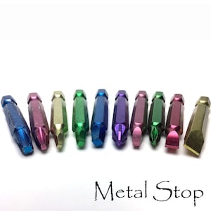 May include: A set of ten colorful metal screwdriver bits. The bits are arranged in a row, with the tips facing the viewer. The bits are all different colors, including blue, green, purple, red, and gold.