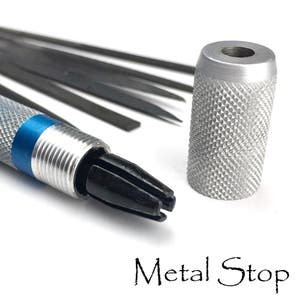 May include: Close-up of a metal tool with a textured silver handle and a blue band. The tool has a black, multi-pronged tip and is accompanied by several thin, dark metal rods. The text "Metal Stop" is visible.