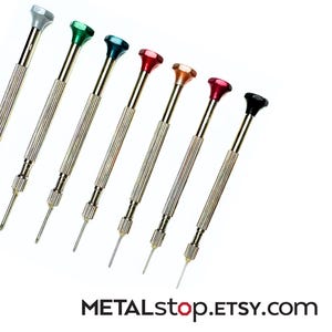 May include: A set of seven small screwdrivers with silver shafts and colored tops. The tops are silver, green, dark blue, red, orange, pink, and black. The text "METALstop.ETSY.com" is at the bottom of the image.
