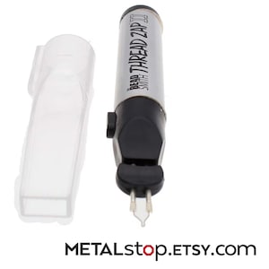 Könnte beinhalten: Ein silbernes und schwarzes Bead Smith Thread Zap II Werkzeug mit einer transparenten Kunststoffschutzhülle. Das Werkzeug trägt den Text "Bead Smith Thread Zap II" auf der Seite. Das Werkzeug ist für Bastelarbeiten und die Schmuckherstellung konzipiert.