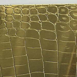 May include: A gold metal bottle stopper with a crocodile skin pattern. The stopper has the text "Metal Stop" printed on the bottom.